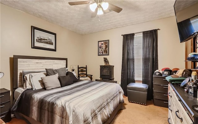 carpeted bedroom with ceiling fan and a textured ceiling