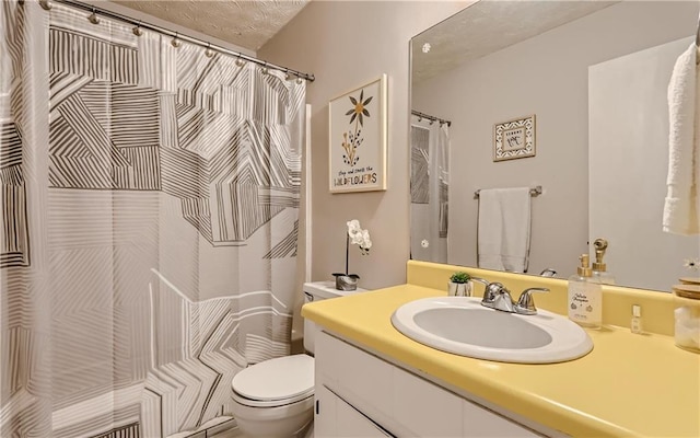 bathroom featuring vanity, a textured ceiling, and toilet