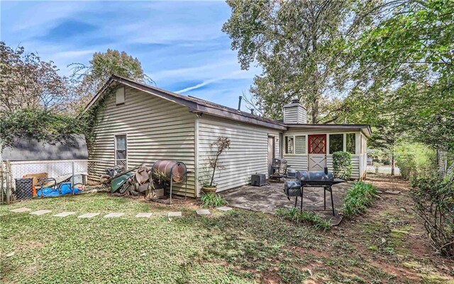 rear view of house featuring a yard and a patio