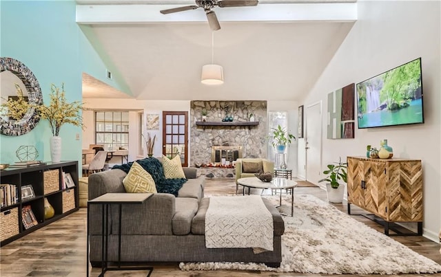 living room featuring ceiling fan, wood-type flooring, plenty of natural light, and a fireplace