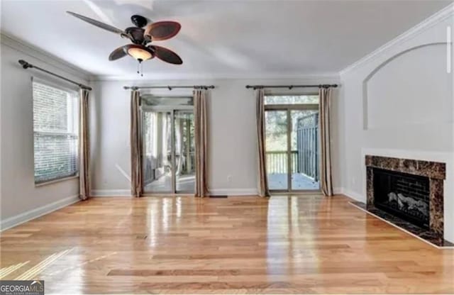 unfurnished living room with ornamental molding, plenty of natural light, and wood finished floors