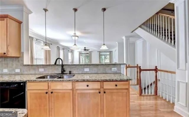 kitchen with a peninsula, a sink, black dishwasher, backsplash, and light brown cabinetry