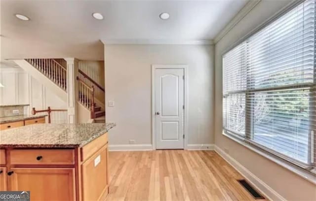 kitchen featuring light wood finished floors, baseboards, visible vents, light stone counters, and recessed lighting