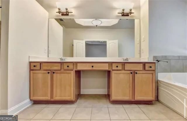 bathroom with a sink, double vanity, a garden tub, and tile patterned floors