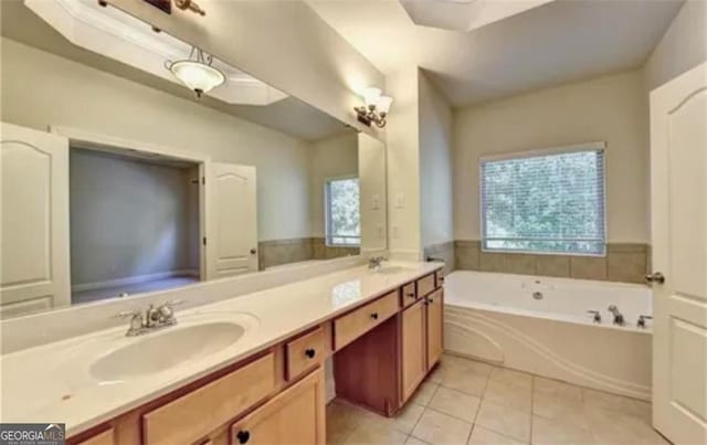 full bathroom with double vanity, a sink, a bath, and tile patterned floors