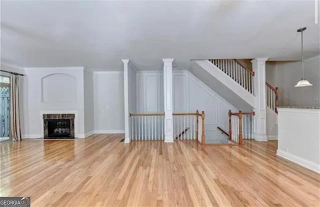 unfurnished living room featuring a fireplace, light wood-style flooring, and baseboards