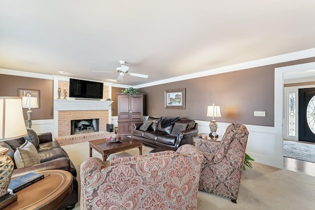 living room featuring a wainscoted wall, ceiling fan, and ornamental molding