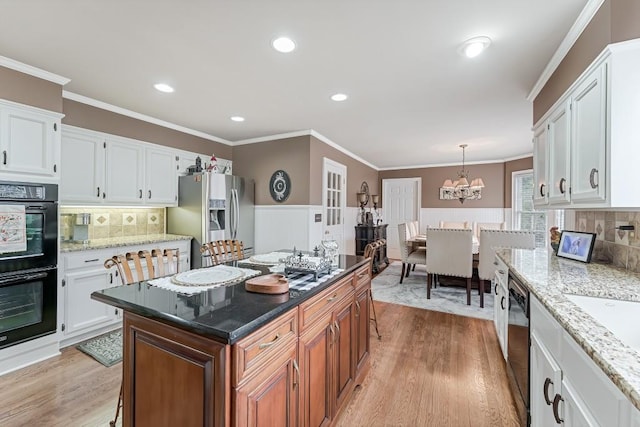 kitchen featuring white cabinets, appliances with stainless steel finishes, and an inviting chandelier