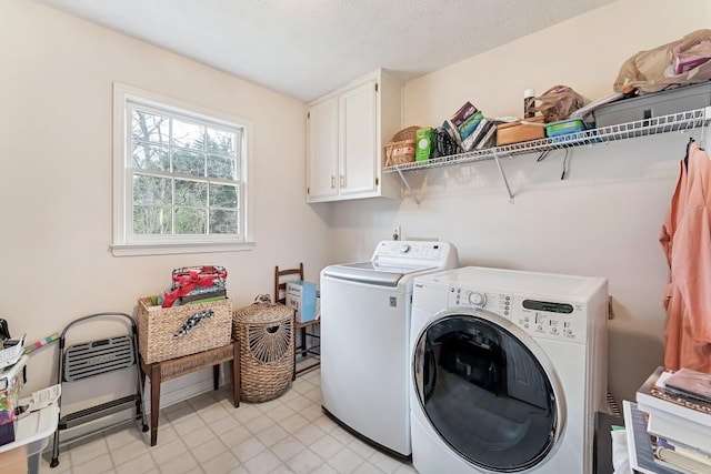 clothes washing area with washing machine and clothes dryer and cabinet space