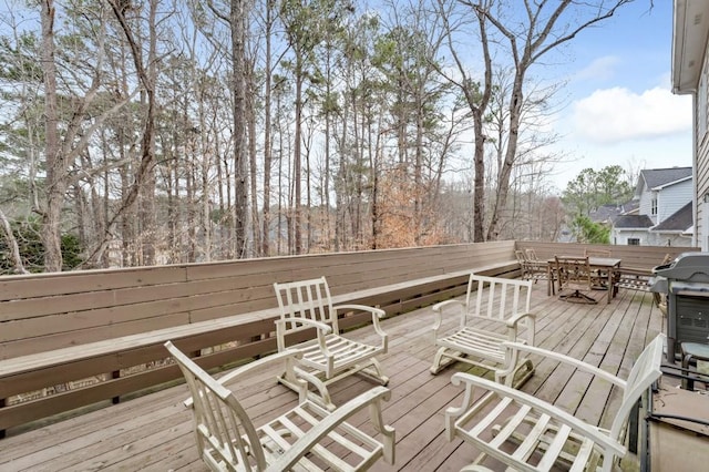 wooden deck featuring a grill and outdoor dining space