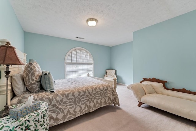 carpeted bedroom featuring visible vents and a textured ceiling