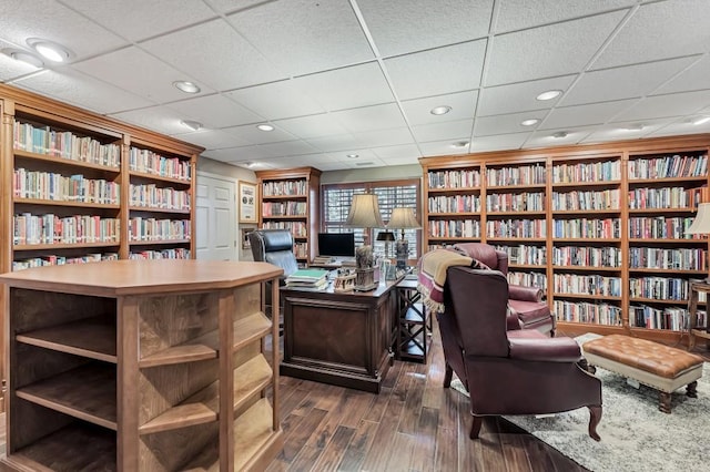 home office featuring recessed lighting, dark wood-type flooring, and bookshelves