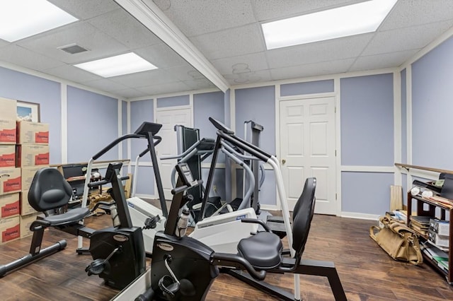 workout area featuring wood finished floors, visible vents, and a paneled ceiling