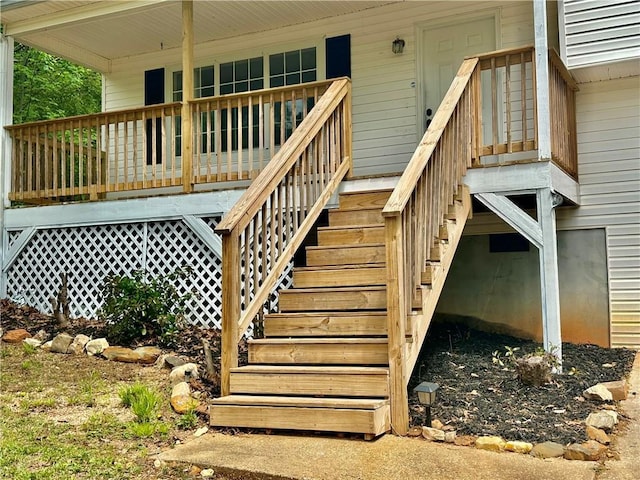 deck featuring covered porch and stairway