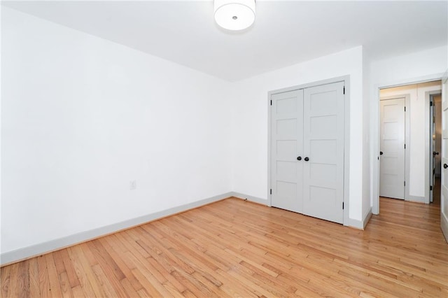 unfurnished bedroom featuring light hardwood / wood-style flooring and a closet