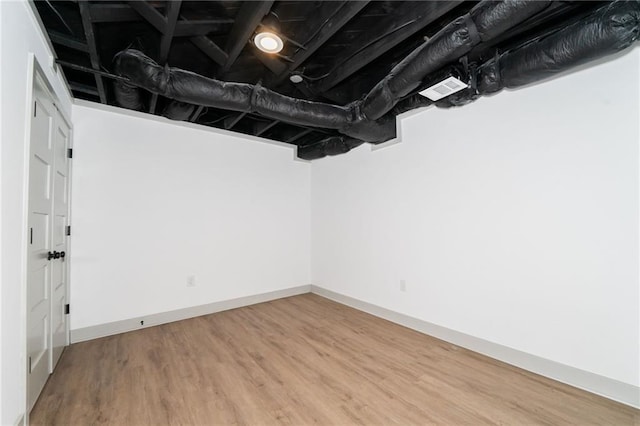 basement with hardwood / wood-style flooring