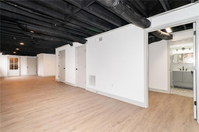 basement with light hardwood / wood-style flooring