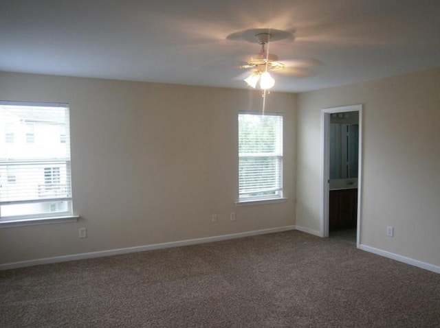 carpeted empty room featuring a wealth of natural light and ceiling fan