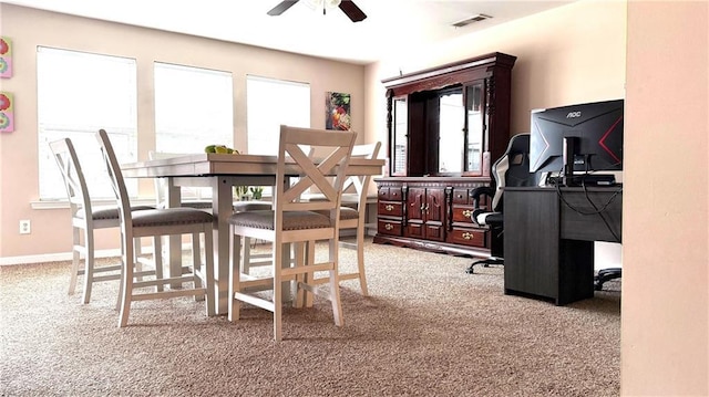 carpeted dining area with ceiling fan