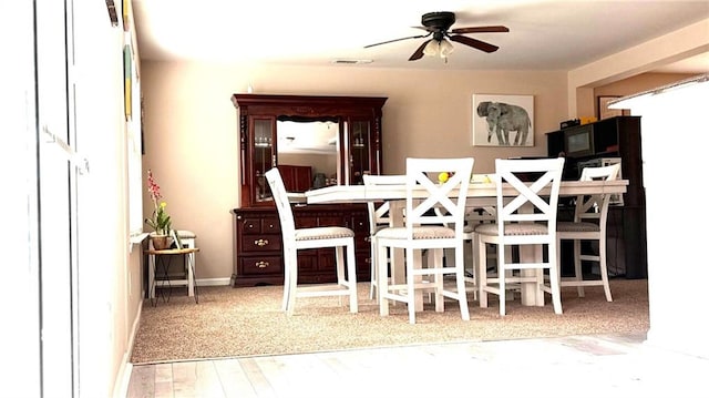 dining area with ceiling fan and hardwood / wood-style floors