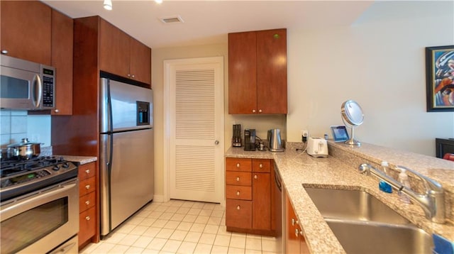 3338 Peachtree Rd NE Unit 1506, Atlanta, GA 30326 - kitchen featuring stainless steel appliances, a sink, light tile patterned floors, light stone counters, and tasteful backsplash