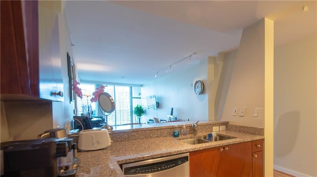 3338 Peachtree Rd NE Unit 1506, Atlanta, GA 30326 - kitchen featuring a sink, dishwasher, open floor plan, track lighting, and brown cabinets