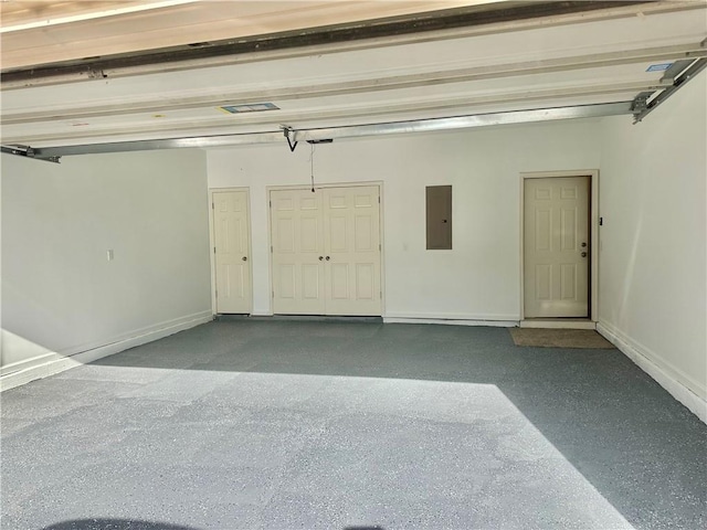 garage with electric panel and baseboards