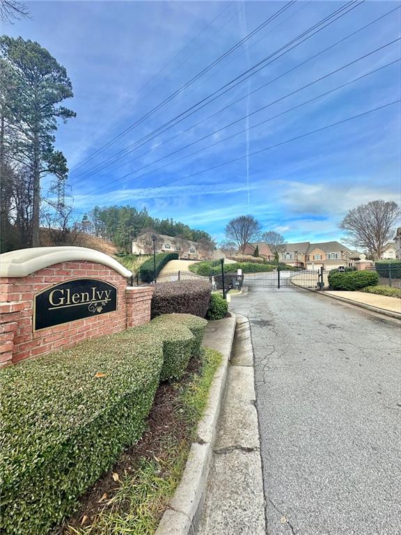 view of street featuring a residential view, a gate, a gated entry, and curbs