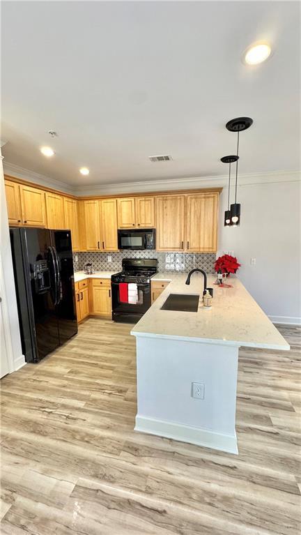 kitchen with visible vents, ornamental molding, a peninsula, black appliances, and a sink