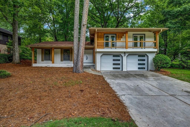 4260 Bonaparte Dr, Tucker, GA 30084 - view of front of property featuring french doors, concrete driveway, an attached garage, brick siding, and covered porch