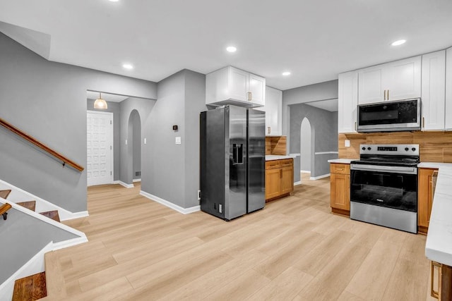 4260 Bonaparte Dr, Tucker, GA 30084 - kitchen featuring stainless steel appliances, arched walkways, light wood-style floors, and recessed lighting
