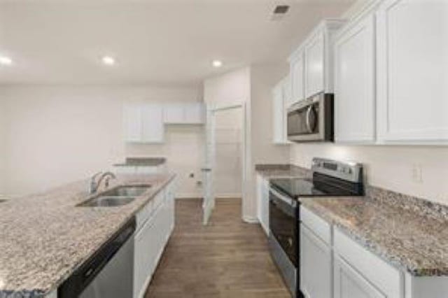kitchen with dark wood-style floors, recessed lighting, white cabinetry, a sink, and appliances with stainless steel finishes