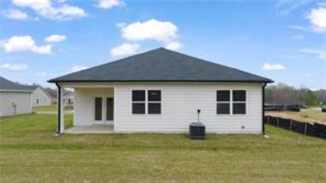 rear view of property featuring a lawn, a patio area, and central air condition unit