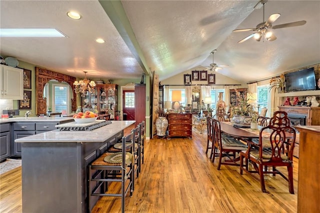 476 Franklin St, Dillard, GA 30537 - kitchen with gray cabinets, ceiling fan, lofted ceiling, light wood-type flooring, and a center island