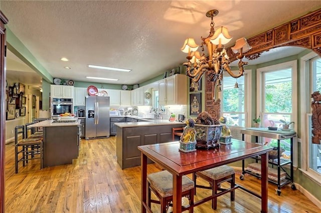 476 Franklin St, Dillard, GA 30537 - kitchen with appliances with stainless steel finishes, light wood-style flooring, light countertops, a kitchen island, and a textured ceiling