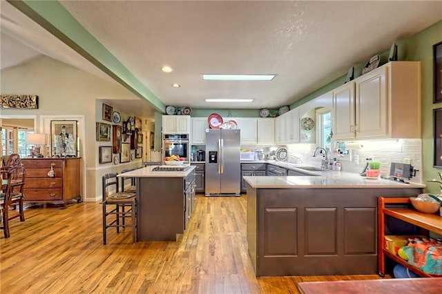 476 Franklin St, Dillard, GA 30537 - kitchen featuring appliances with stainless steel finishes, light wood finished floors, white cabinets, light countertops, and a peninsula