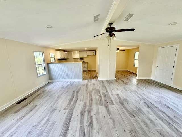 unfurnished living room featuring a healthy amount of sunlight, ceiling fan, light wood-type flooring, and baseboards