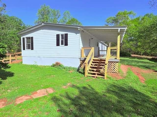 back of house with a wooden deck, a yard, stairway, and fence