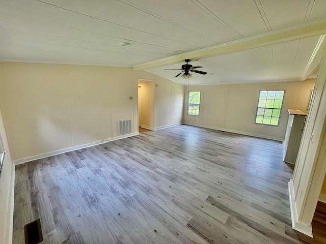 spare room with visible vents, wood finished floors, and a wealth of natural light