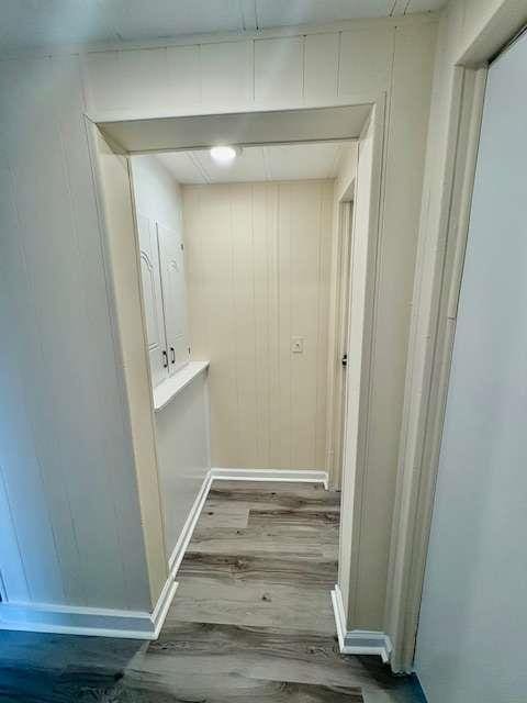 hallway featuring wood finished floors and baseboards