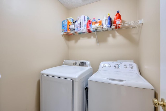 laundry area with a textured ceiling and independent washer and dryer