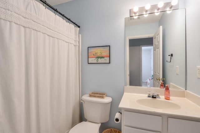 bathroom featuring vanity, walk in shower, and toilet