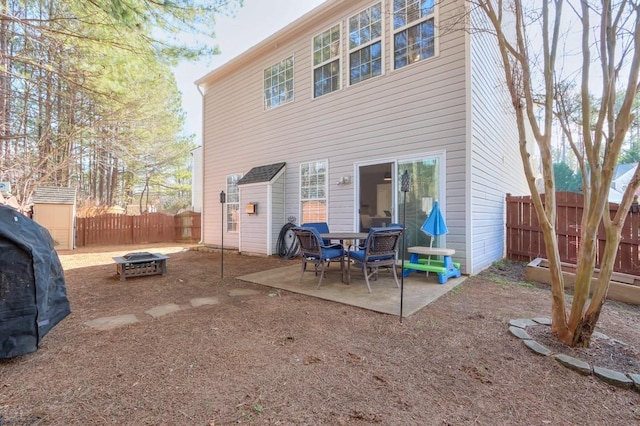 rear view of property featuring a patio area and an outdoor fire pit