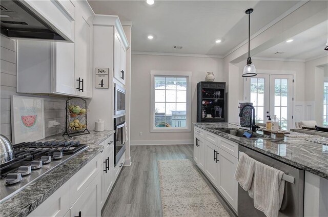 884 Oxford Rd, Ball Ground, GA 30107 - kitchen featuring stainless steel appliances, range hood, light wood-style flooring, white cabinets, and dark stone counters