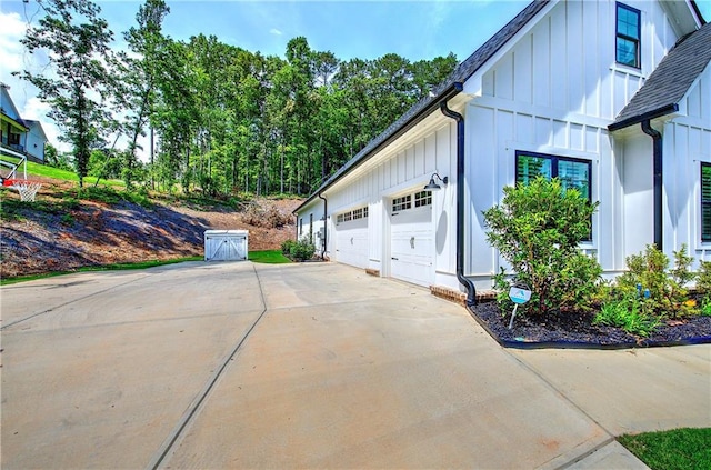 884 Oxford Rd, Ball Ground, GA 30107 - view of home's exterior featuring board and batten siding, driveway, a garage, and roof with shingles