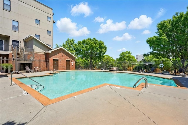 community pool with fence and a patio area