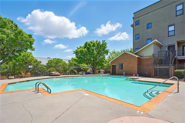 community pool featuring a patio and fence