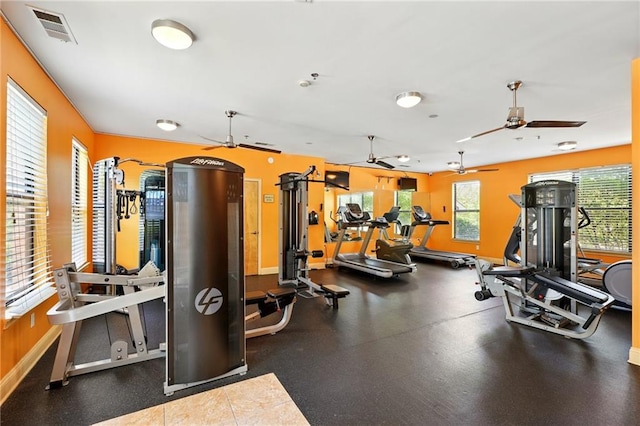 gym with visible vents, ceiling fan, and baseboards