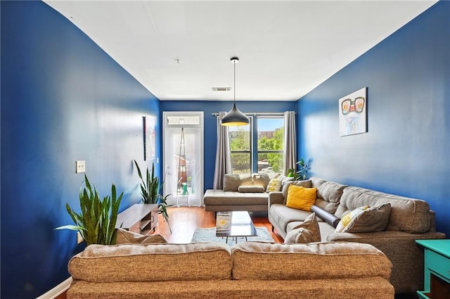 living area featuring visible vents and wood finished floors