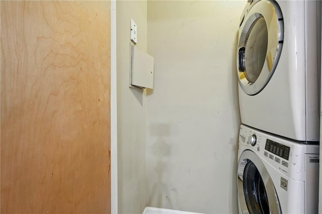 washroom with stacked washer / drying machine and laundry area